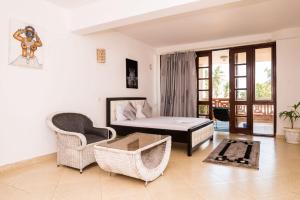 モンバサにあるOne Bedroom Beachfront In Nyali Mombasaのベッドとテーブルと椅子のあるリビングルーム