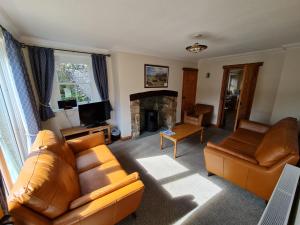 a living room with a couch and a fireplace at Coach House in Penrith