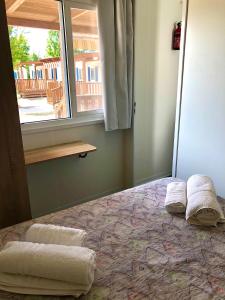 a bedroom with a bed with towels on it at Camping Village Nice Garden in Ardea