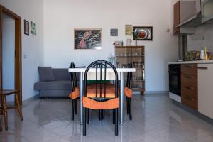 una mesa y sillas en una cocina con sofá en Regina di Puglia Casa Vacanze, en Monopoli