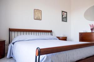 1 dormitorio con 1 cama grande con sábanas blancas en Regina di Puglia Casa Vacanze, en Monopoli
