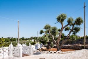 una cerca blanca con dos árboles en un cementerio en Regina di Puglia Casa Vacanze, en Monopoli