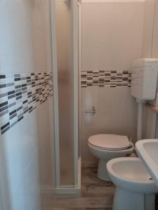 a bathroom with a toilet and a sink and a shower at Helios Beach Hotel in Milano Marittima
