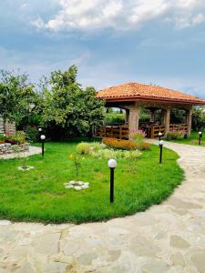 a garden with a gazebo with flowers in the grass at Galaktioni's Marani in Kondoli