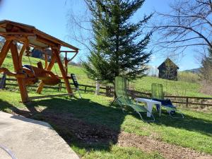 twee stoelen en een picknicktafel naast een hek bij Cabana Aura Campulung Moldovenesc in Câmpulung Moldovenesc