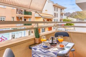 uma mesa com dois copos de sumo de laranja numa varanda em Espectacular Apartamento em Port de Pollensa