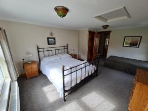 a bedroom with a bed and a nightstand and a bedsenalsenalsenalsenal at Stable Cottage in Penrith