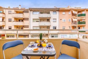 uma mesa e cadeiras numa varanda com um edifício em Espectacular Apartamento em Port de Pollensa