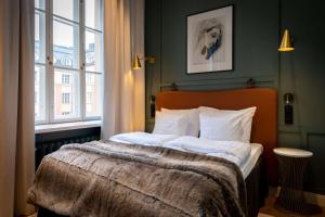 Schlafzimmer mit einem Bett mit weißer Bettwäsche und einem Fenster in der Unterkunft Scandic Grand Central Helsinki in Helsinki