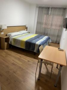 Uleila del Campo的住宿－埃斯卡帕德旅館，一间小卧室,配有一张床和一张桌子