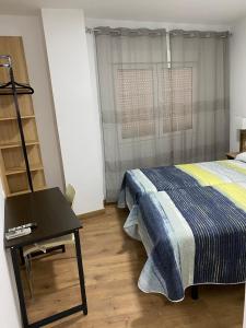 1 dormitorio con 1 cama, 1 mesa y 1 silla en La Escapada, en Uleila del Campo