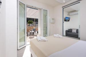 una camera bianca con letto e balcone di Rivazzurra Vivimare Apartment a San Vito lo Capo
