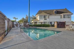 ein Haus mit einem Pool vor einem Haus in der Unterkunft Motel 6-Fresno, CA - Belmont Ave in Fresno