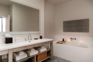 a bathroom with a tub and a sink and a mirror at Andaz Scottsdale Resort & Bungalows in Scottsdale