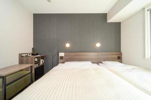 1 dormitorio con 1 cama grande y escritorio en Super Hotel Hiroshima Yagenboridori en Hiroshima