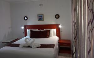 um quarto com uma cama com um arco branco em Rest Shade Bed and Breakfast em Palapye