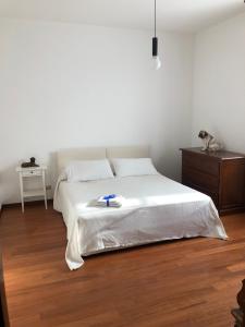 um quarto com uma cama branca e piso em madeira em VILLA SECCHI em Castrezatto