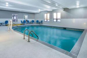 Baymont by Wyndham Rochester Mayo Clinic Area في روتشستر: مسبح ذو كراسي زرقاء في مبنى