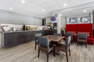 a restaurant with a table and chairs and a counter at Baymont by Wyndham Rochester Mayo Clinic Area in Rochester