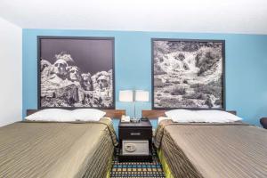 a hotel room with two beds and a painting on the wall at Super 8 by Wyndham North Sioux City in North Sioux City