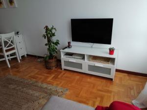 uma sala de estar com televisão num centro de entretenimento branco em Apartamento Conlledo em Villaviciosa