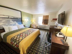 Habitación de hotel con cama grande y escritorio. en Super 8 by Wyndham Newport News/Jefferson Ave., en Newport News