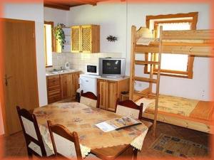 a kitchen and dining room with a table and a bunk bed at Motylek 4 in Borušov