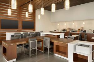 Wingate by Wyndham Murfreesboro-NEAR MTSU في مورفريسبورو: غرفة طعام مع طاولة وكراسي طويلة