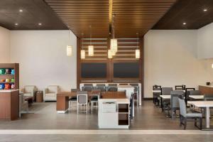 - une salle à manger avec des tables et des chaises dans l'établissement Wingate by Wyndham Murfreesboro-NEAR MTSU, à Murfreesboro