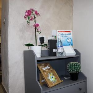 a gray shelf with flowers on top of it at Meghan Home in Catania