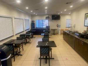 a restaurant with tables and chairs in a room at SureStay Plus by Best Western Edmond in Edmond