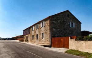 a stone building on the side of a road at A Casa do Folgo Turismo Rural in Negreira