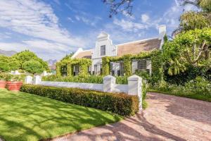 Ein weißes Haus, auf dem Efeu wächst. in der Unterkunft Van der Stel Manor in Stellenbosch