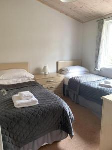 a bedroom with two beds and a window at Park Lodge in Penrith