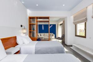 a bedroom with two beds and a living room at CHRISTOS Élite Sea View Suite Adults Only in Plakias