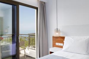 um quarto com uma cama e uma varanda em CHRISTOS Élite Sea View Suite Adults Only em Plakiás