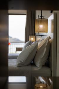 um quarto com uma cama com almofadas e uma janela em CHRISTOS Élite Sea View Suite Adults Only em Plakiás