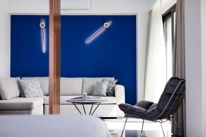uma sala de estar com um sofá e uma parede azul em CHRISTOS Élite Sea View Suite Adults Only em Plakiás