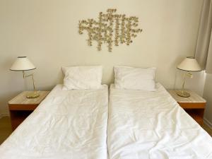 a bedroom with two beds with white sheets and two lamps at Kverna Guesthouse in Skogar