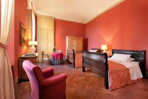 a bedroom with red walls and a bed and chairs at Castello Di San Sebastiano Po in Chivasso