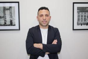 a man standing with his arms crossed in front of some art at Meghan Home in Catania