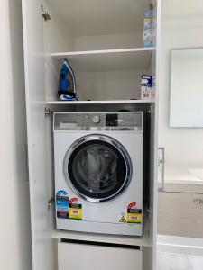 a washer and dryer in a small room at Coromandel Town Harbourside Cottage Luxury Accommodation in Coromandel Town