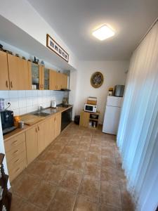 eine Küche mit Holzschränken und Fliesenboden in der Unterkunft Villa Janja in Šilo