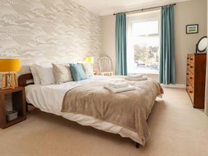 a bedroom with a large bed and a window at Castlewood Cottage in Skipton