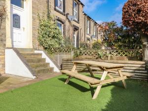 a wooden picnic table in front of a building at Castlewood Cottage in Skipton