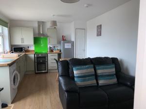 a living room with a black couch in a kitchen at Out Bac in Saint Breward