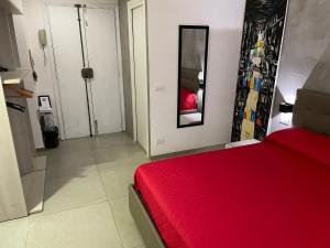een slaapkamer met een rood bed en een spiegel bij Napoli Via Toledo in Napels +8 foto's