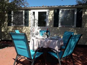 a table with blue chairs and a bottle of wine at Camping Torkul in Kraj