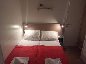 een rood en wit bed in een kleine kamer bij Camping Torkul in Kraj