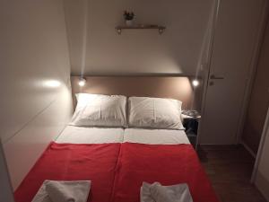 a red and white bed in a small room at Camping Torkul in Kraj